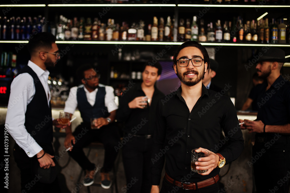 Stylish arab man against group of handsome retro well-dressed guys gangsters spend time at club, drinking on bar counter. Multiethnic male bachelor mafia party in restaurant. Stylish arab man against group of handsome retro well-dressed guys gangsters spend time at club, drinking on bar counter. Multiethnic male bachelor mafia party in restaurant.