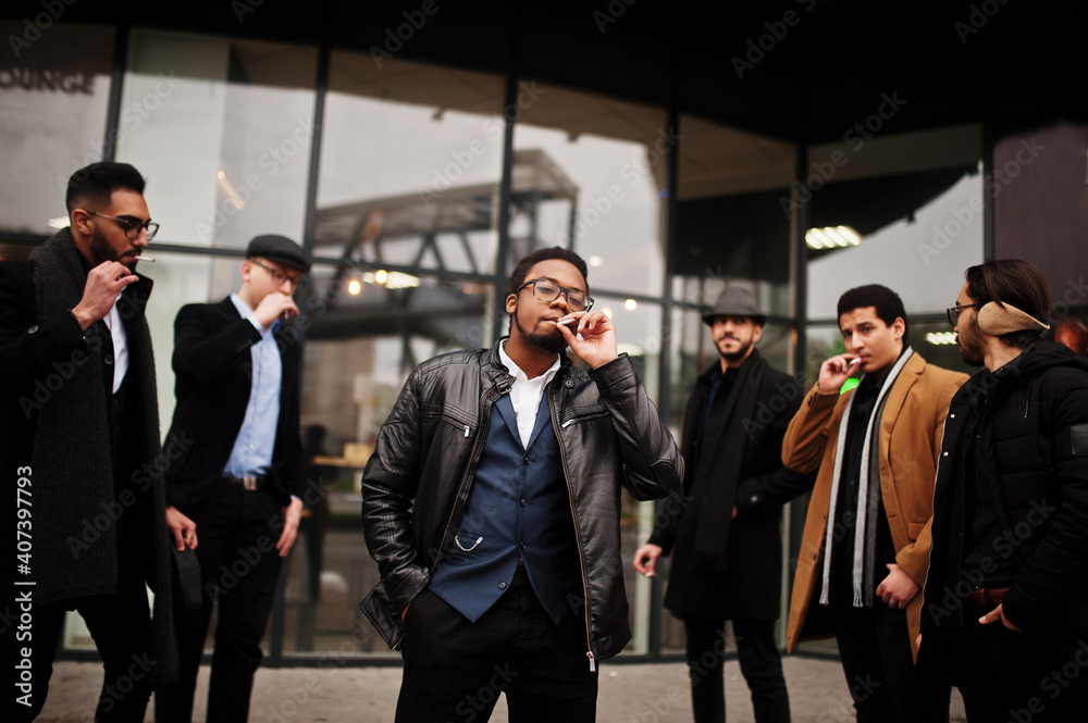Group of handsome retro well-dressed man gangsters smoking outdoor. Multiethnic male bachelor mafia party. Group of handsome retro well-dressed man gangsters smoking outdoor. Multiethnic male bachelor mafia party.