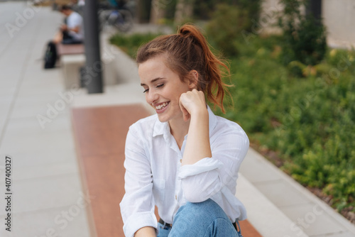 young woman looks down laughing