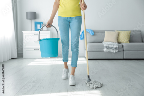 Murais de parede Woman with mop and bucket at home, closeup. Cleaning supplies