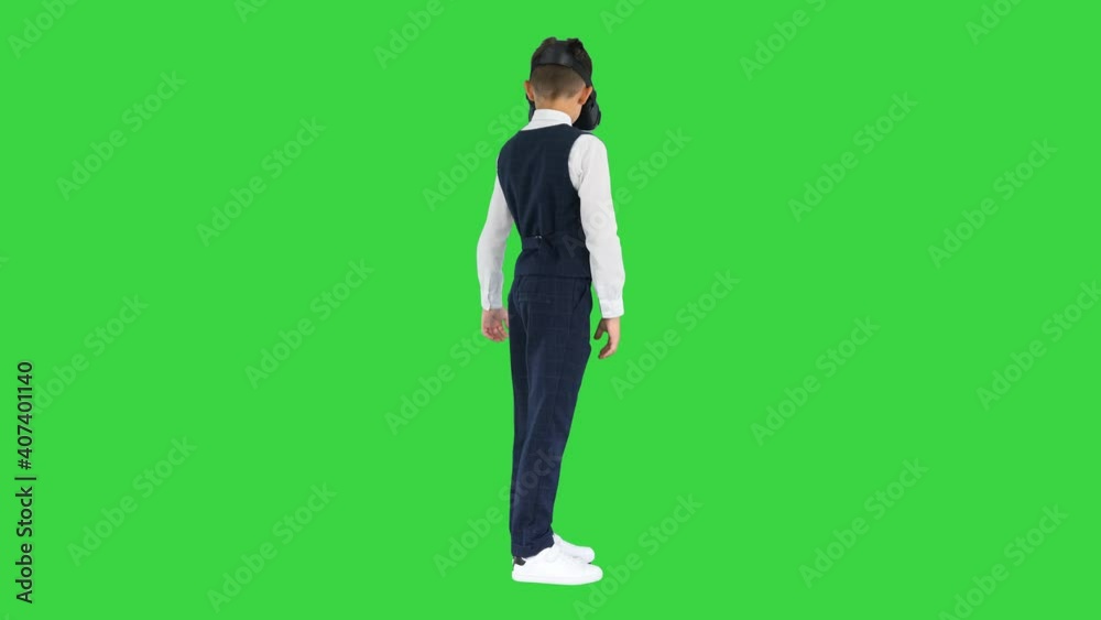 Boy in formal wear playing the game in virtual reality goggles on a Green Screen, Chroma Key. Boy in formal wear playing the game in virtual reality goggles on a Green Screen, Chroma Key.