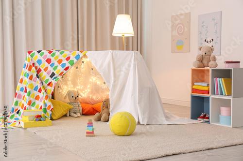 Fotografie Play tent decorated with festive lights in modern child's room