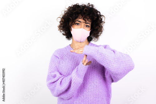 young beautiful caucasian woman wearing medical mask standing against white wall being upset showing a timeout gesture, needs stop, asks time for rest after hard work, demonstrates break hand sign © Roquillo