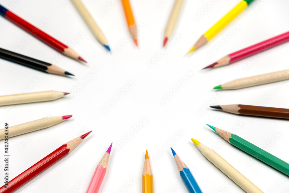 wooden colored pencils close up lie in a circle on a white blurred background wooden colored pencils close up lie in a circle on a white blurred background