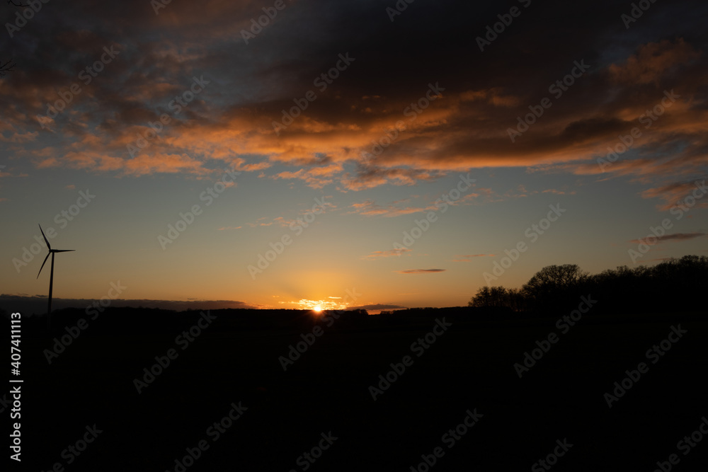 Black Silhouette of windturbines energy generator on amazing sunset at a wind farm in langenberg, germany