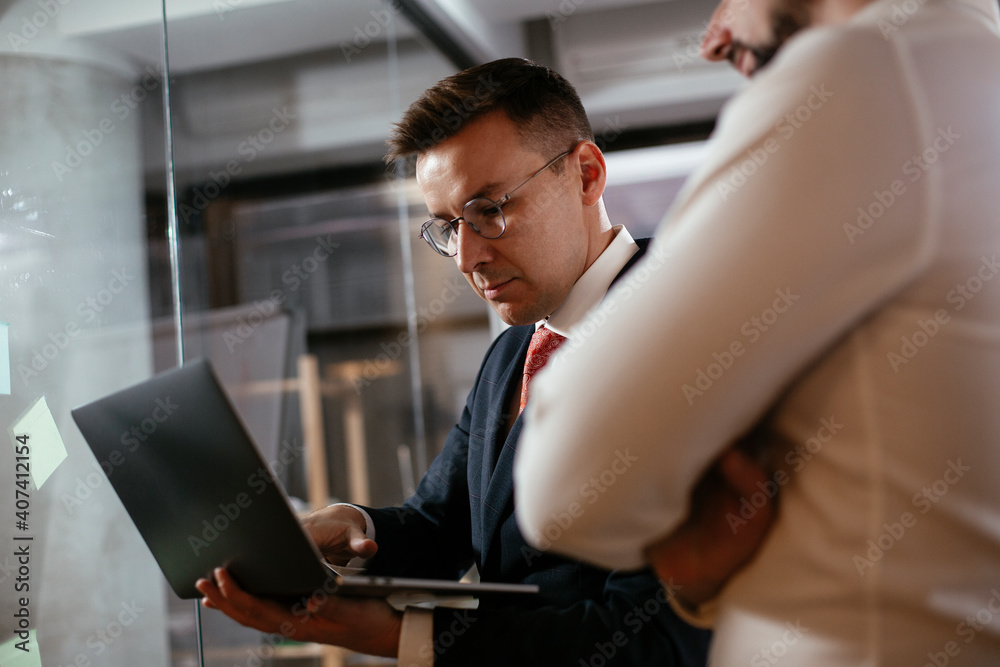 Businessmen in the office. Colleagues in conference room making a business plan. Two man working together on new project. Businessmen in the office. Colleagues in conference room making a business plan. Two man working together on new project.