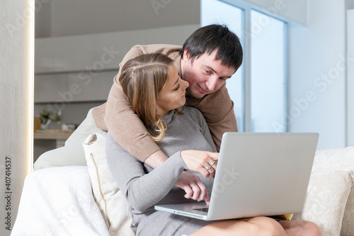 A young couple is sitting on the couch and shopping online.