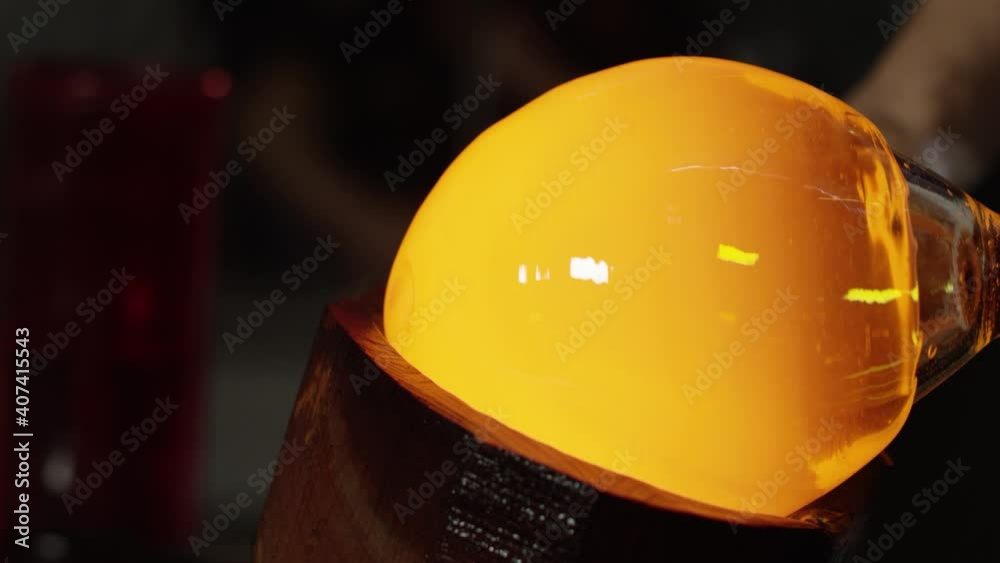 Glassworks manufacturing process . Production of glass bottles . Bottle manufacturing industrial factory . Molten glass . Glass factory . Process of creating glass products . Slow motion . Close up .