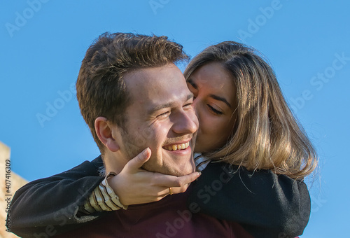 Smiling Man Giving Piggy Back To His Girlfriend In Park. © Nanci