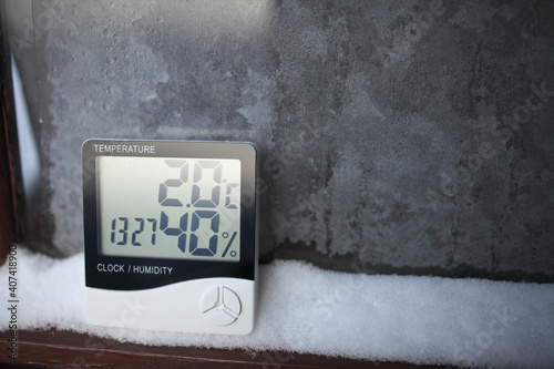 The humidity indicator is indicated on a hygrometer installed on the snow. Picture of an electronic device for testing air temperature and humidity. photo