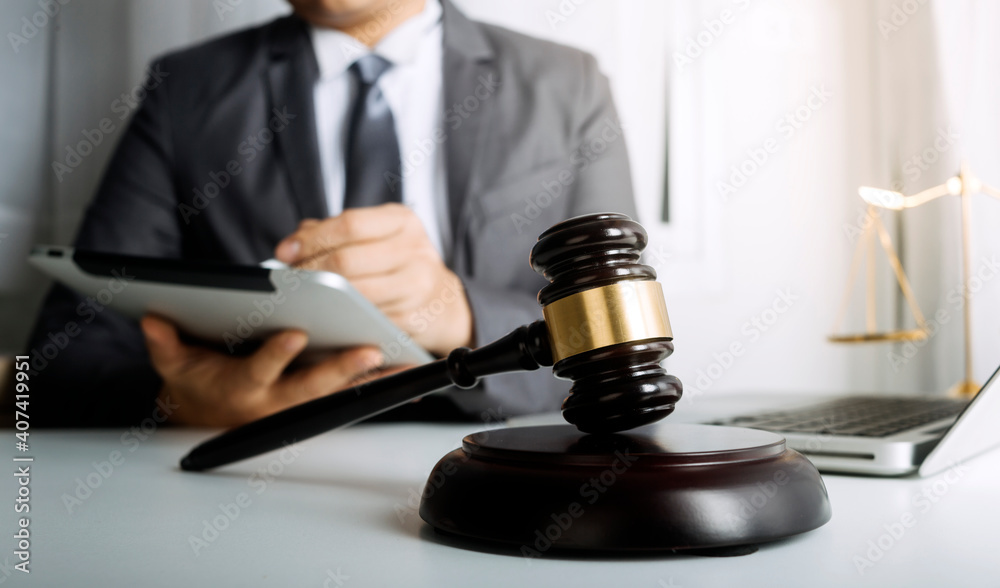 Business and lawyers discussing contract papers with brass scale on desk in office. Law, legal services, advice, justice and law concept picture with film grain effect Business and lawyers discussing contract papers with brass scale on desk in office. Law, legal services, advice, justice and law concept picture with film grain effect