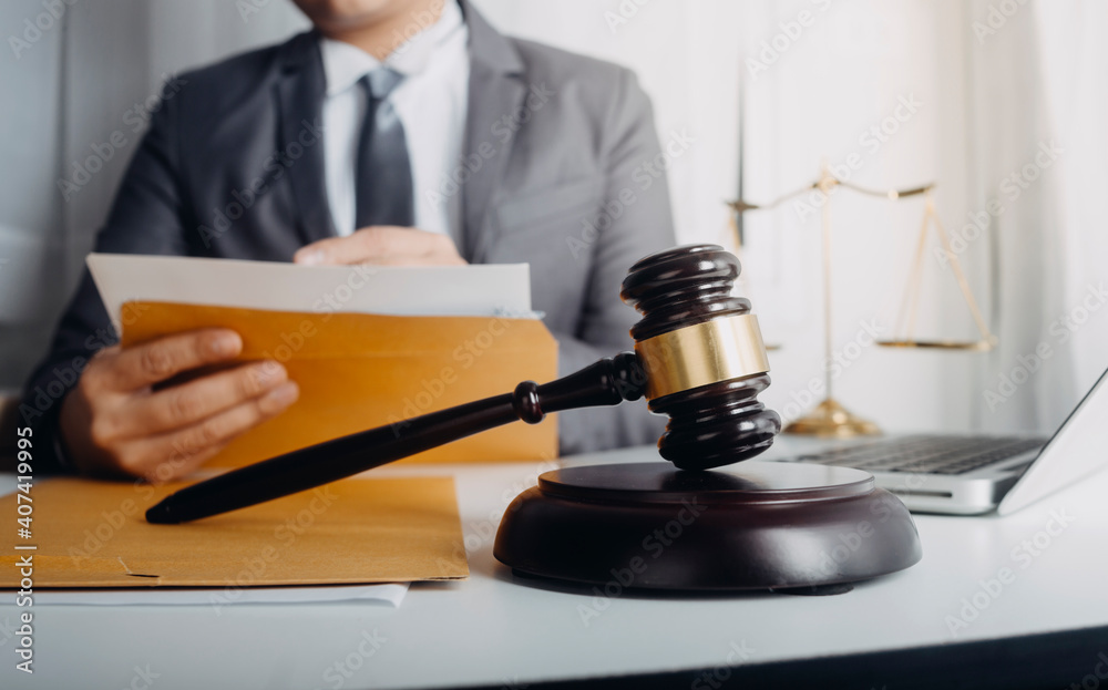 Business and lawyers discussing contract papers with brass scale on desk in office. Law, legal services, advice, justice and law concept picture with film grain effect Business and lawyers discussing contract papers with brass scale on desk in office. Law, legal services, advice, justice and law concept picture with film grain effect