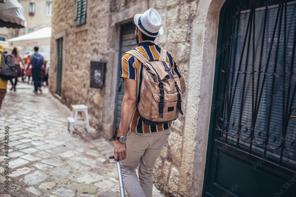 Handsome bearded tourist with backpack is making travel across city. Handsome bearded tourist with backpack is making travel across city.
