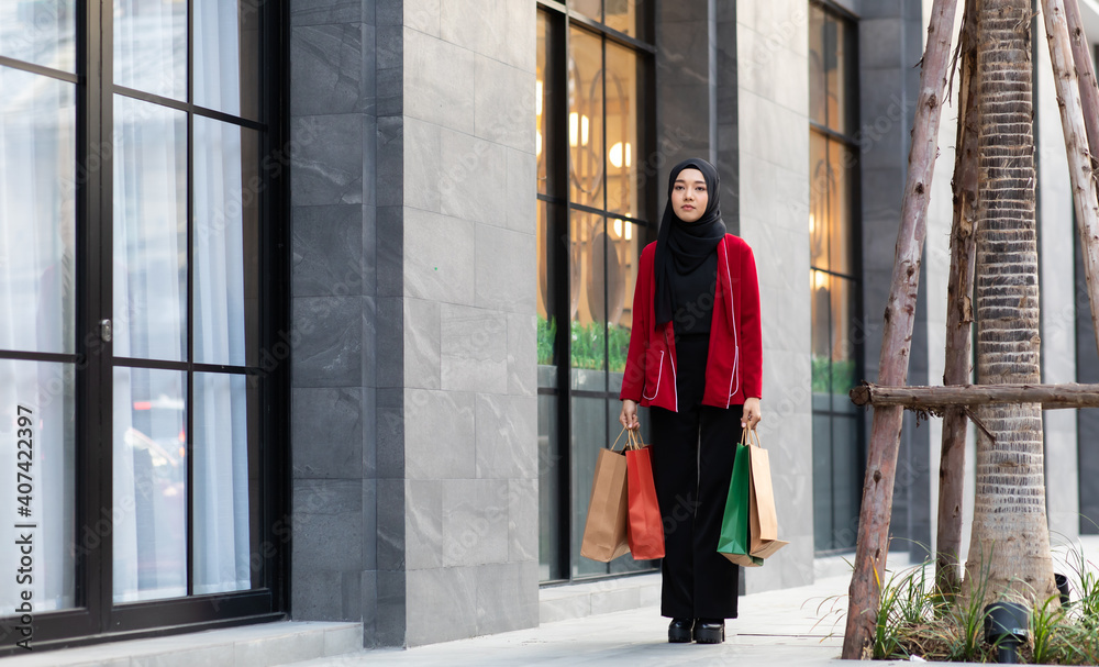 People Shopping Concept. Young beautiful muslim woman with shopping bags walking at the mall