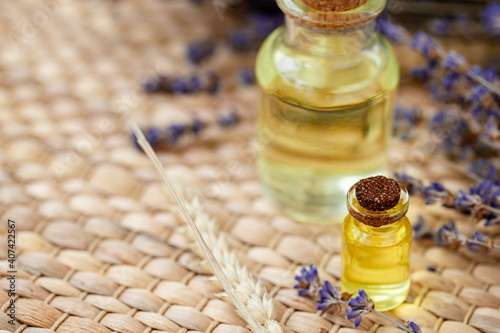 Organic natural essential lavender oil in glass bottles. Dry flowers  wooden background. Spa products for relaxation  aromatherapy. Concept of herbal cosmetics. Close up  macro  copy space for text