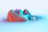 Profile. Beautiful female face in the milk bath with soft glowing in blue-pink neon light. Copyspace for advertising. Modern neoned colors, foam. Beauty, fashion, style, skincare concept. Attractive.