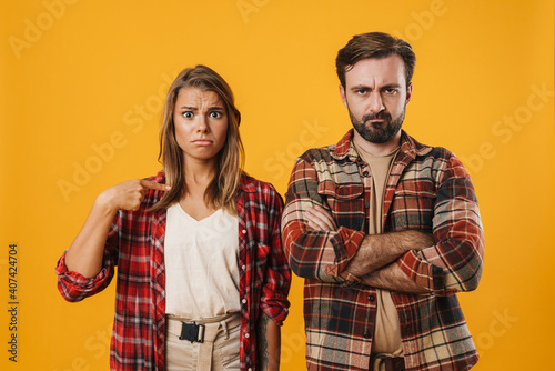 Offended blonde woman pointing finger at displeased man