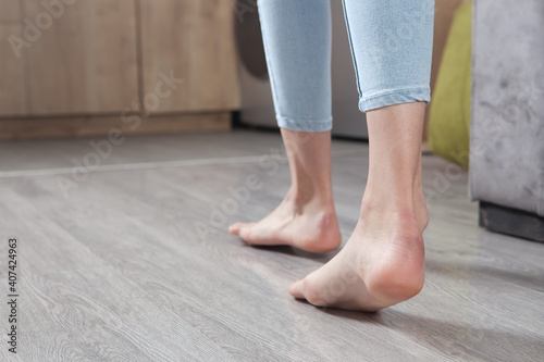 Female feet walking on floor at home. © andranik123