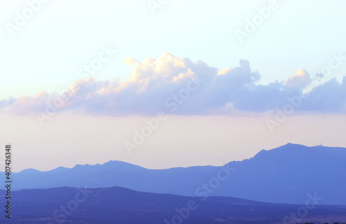 Sierra de Guadarrama vista desde el norte de la ciudad de Madrid, España. Fondo natural donde se aprecia la silueta de las montañas y las nubes con los últimos rayos de sol del día.