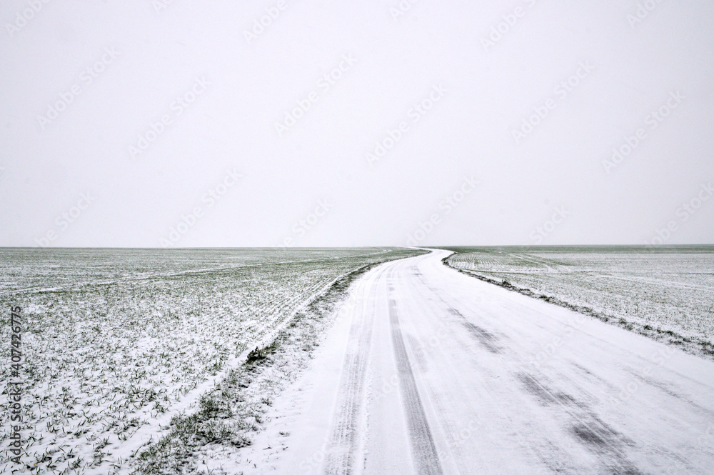 A snowy country road, dangerous and slippery during winter snowfall. A snowy country road, dangerous and slippery during winter snowfall.