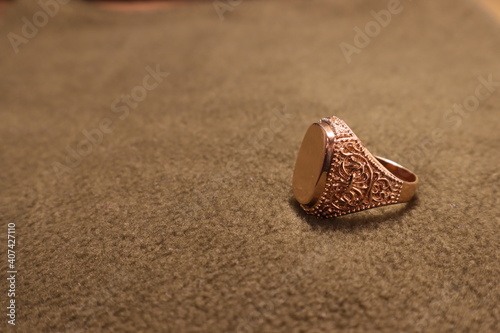 Mens gold signet ring on a beige background. photo