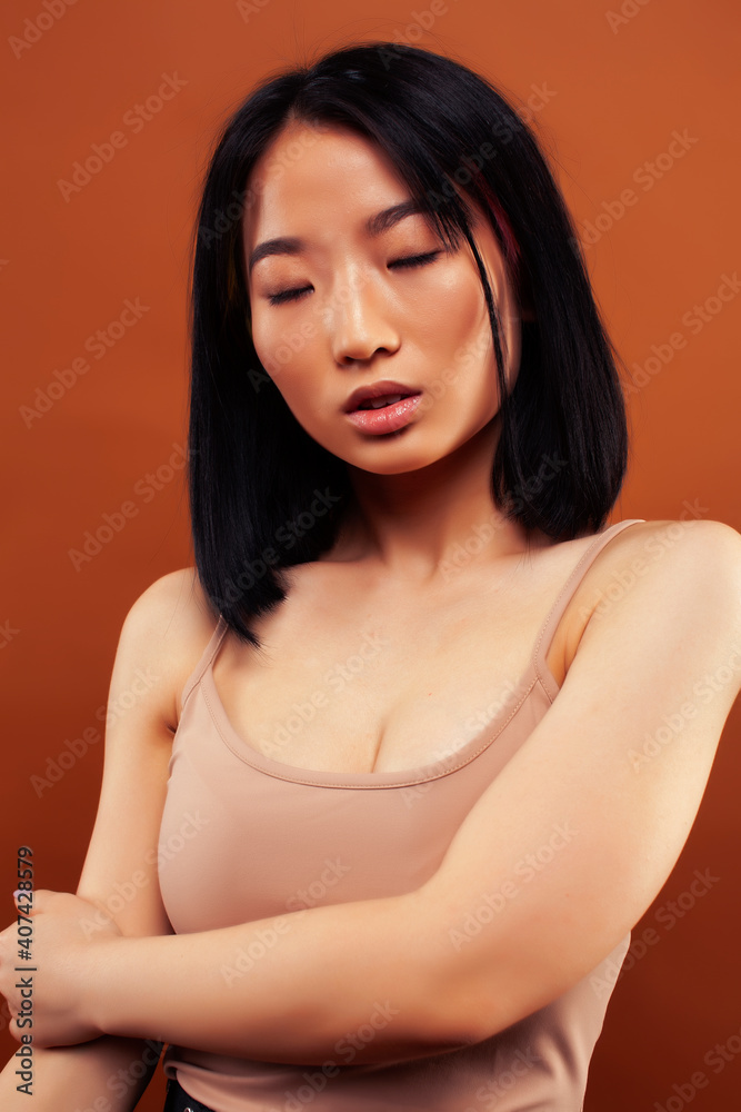 young pretty asian woman cheerful smiling posing on warm brown background, lifestyle people concept young pretty asian woman cheerful smiling posing on warm brown background, lifestyle people concept