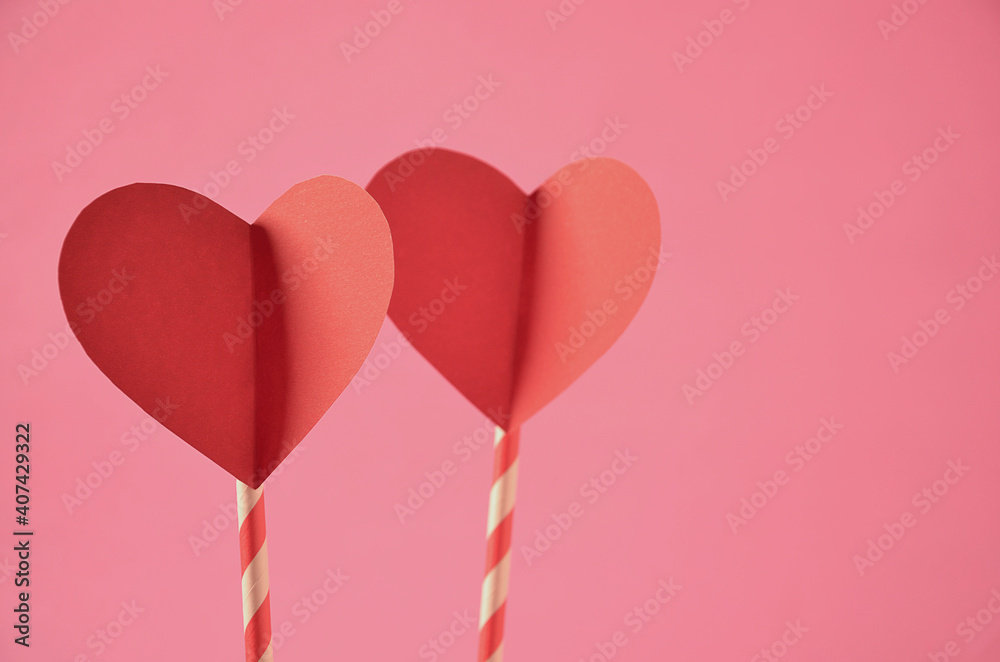 two chopsticks with red hearts and pink background