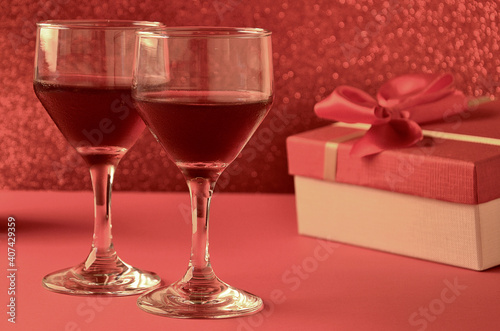 two wine glasses with gift and festive background