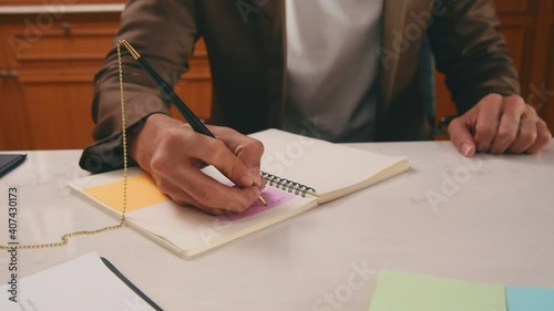 Business man review document contract on work desk and using pen to write to the book in office room