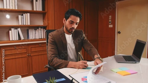 Business man review document contract on work desk and using pen to write to the book in office room