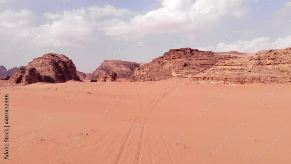 Aerial flyover sandy dusty desert and beautiful mountain range landscape in background. Sunny day in Wadi Rum Desert,Jordan. Aerial flyover sandy dusty desert and beautiful mountain range landscape in background. Sunny day in Wadi Rum Desert,Jordan.
