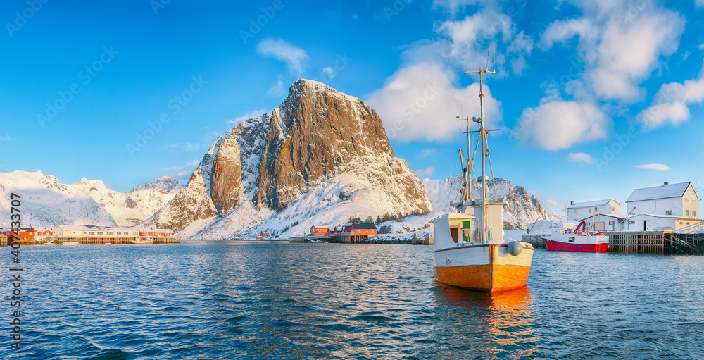 Amazing winter view on Hamnoy village with port and Festhaeltinden mountain on background.