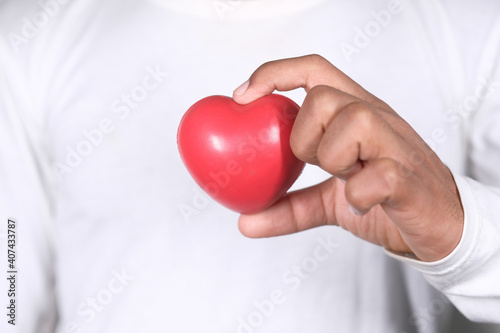 young man holding red heart on white 
