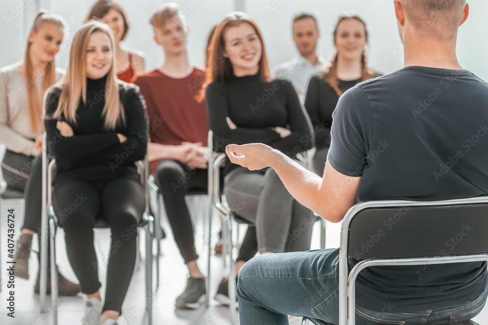 Obraz premium speaker and a group of young people sitting in a conference room