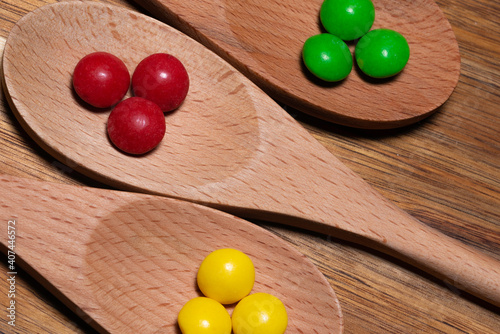 Three wood spoons with colorful candies