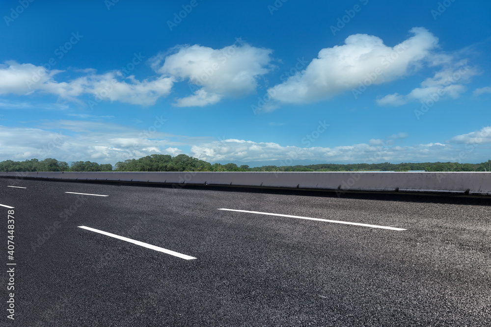 Asphalt ground and blue sky with white clouds