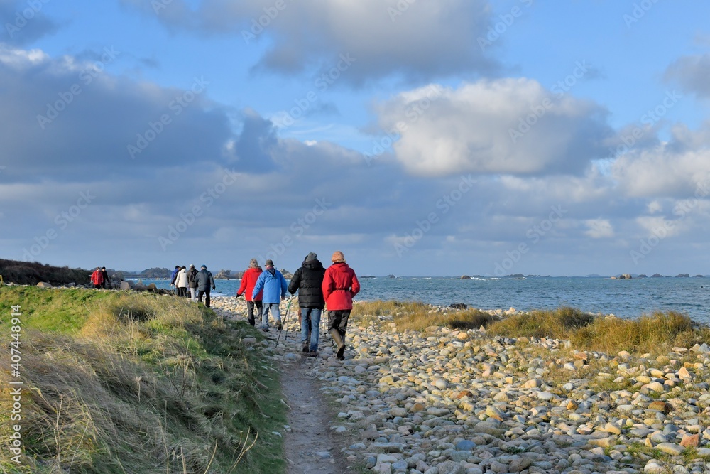 Hikers on the path along the coast at Plougrescant in Brittany. France