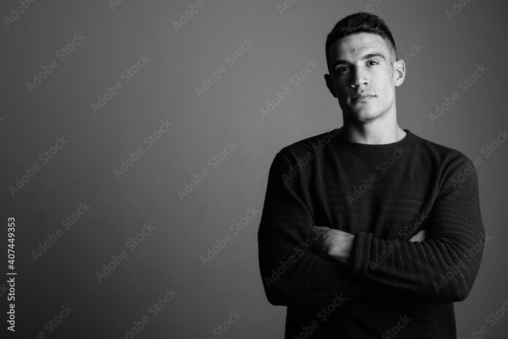 Young handsome man wearing sweater against gray background Young handsome man wearing sweater against gray background