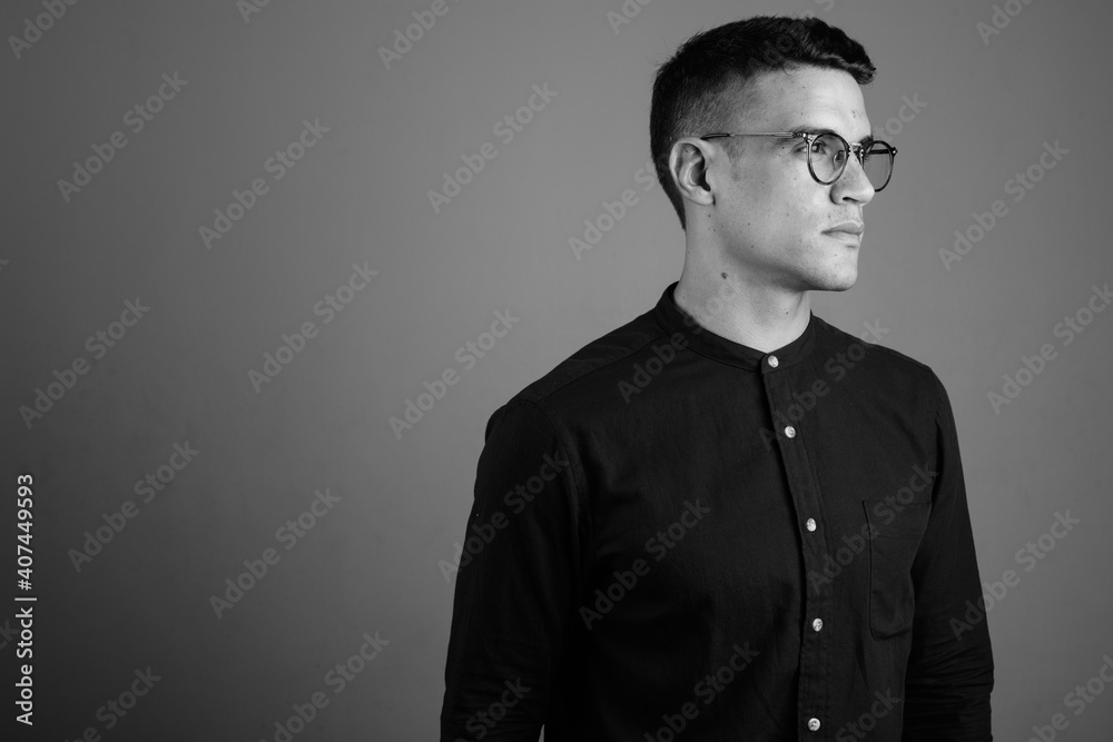 Young handsome businessman wearing eyeglasses against gray background Young handsome businessman wearing eyeglasses against gray background