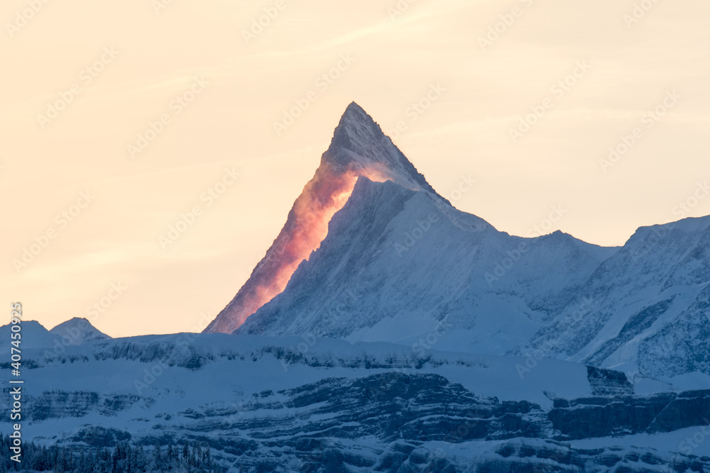 peak of Finsteraarhorn at dawn with red clouds in winter