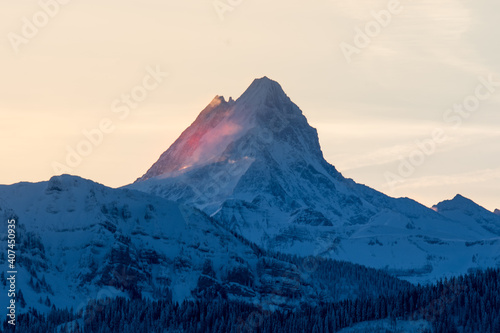 peak of Schreckhorn at dawn with red clouds in winter © schame87