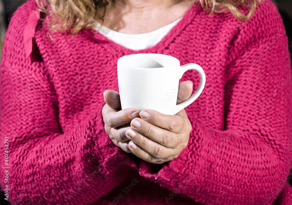 Adult woman with red sweater holding a cup of latte coffee Adult woman with red sweater holding a cup of latte coffee