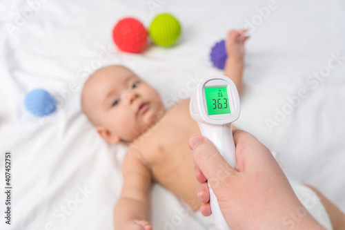 Infrared thermometer aimed at the child. Selective focus