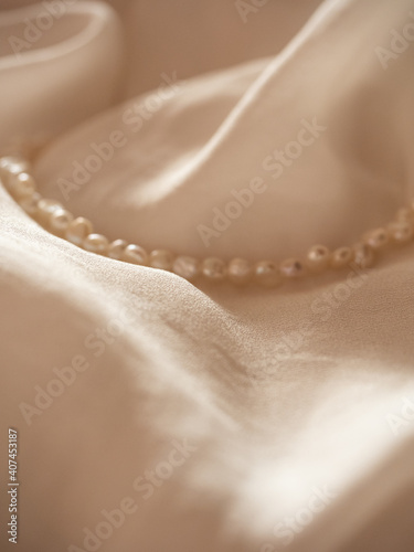 Delicate flowing milky silk with a string of baroque pearls in the morning light