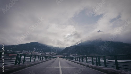 Roadway on the bridge to a distant mountains in clouds, French Alps photo