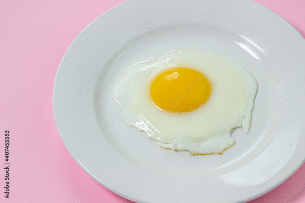 Scrambled eggs on a pink background. Fried eggs on a white plate. Tasty breakfast. Scrambled eggs on a pink background. Fried eggs on a white plate. Tasty breakfast.