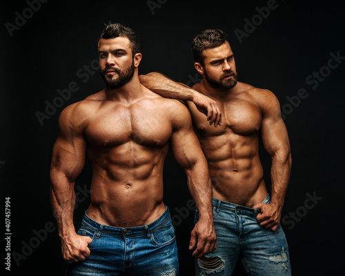 Two hunks standing at black background