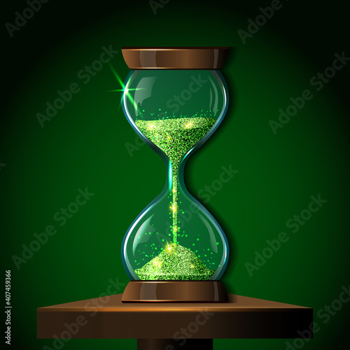 Transparent vector sandglass with emerald green glitter on table. Realistic 3D bright sparkly sand clock illustration. Modern gleaming hourglass. Magic timer
