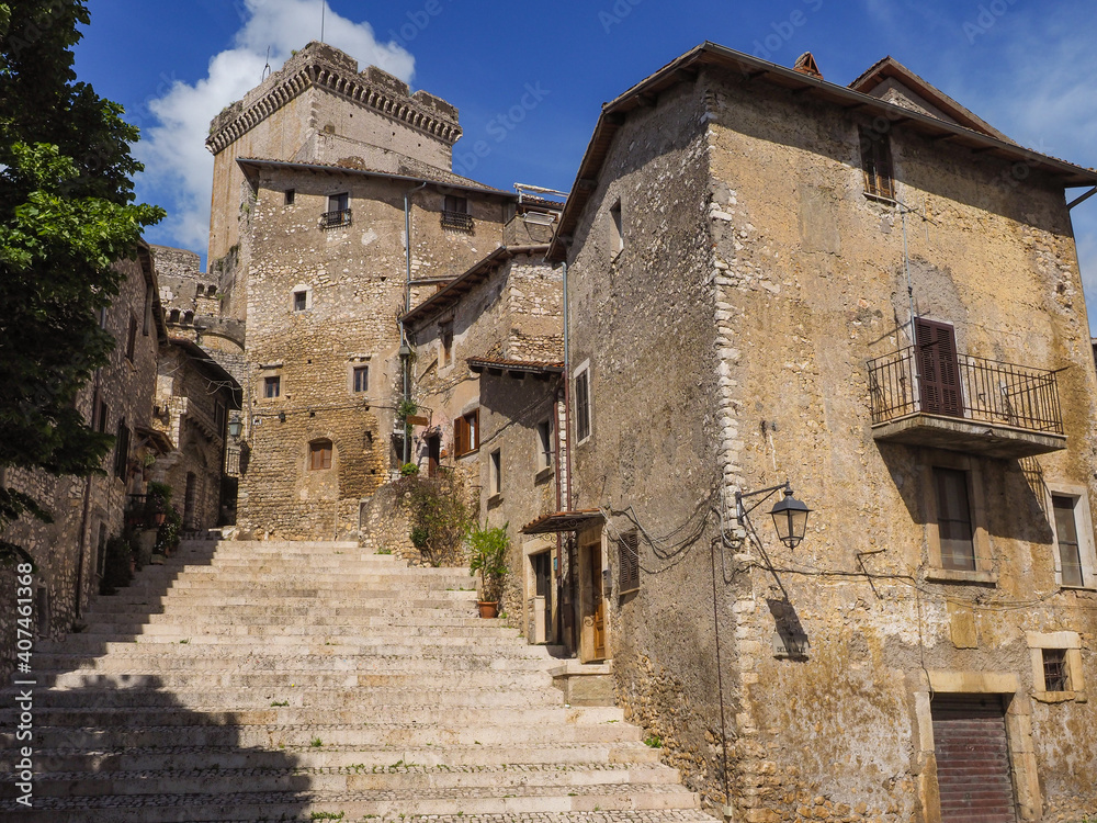 Beautiful Sermoneta town center with a wide stairs and old medieval houses with the view of the famous Caetani Castle Tower on top. Traditional Italian landscape. Summer day and blue sky background.