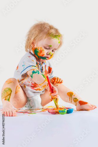 The little boy painted his face, hands and clothes with paint. Children's pranks.